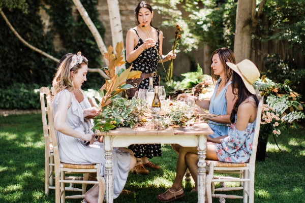 Woman teaching friends how to make bouquets at a DIY bouquet making party