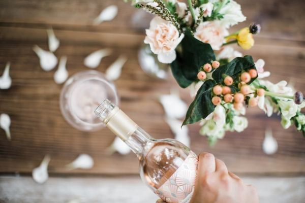 A handmade bouquet next to a glass of AVA Grace