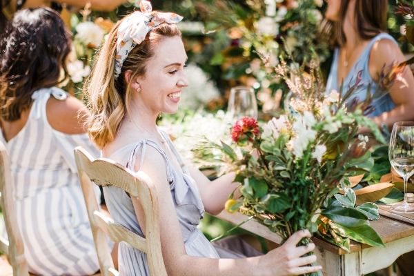 A woman smiling at a homemade bouquet