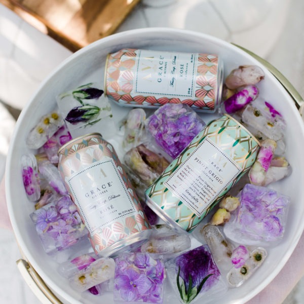 Can of AVA Grace wines in an ice bucket with beautiful floral ice cubes.