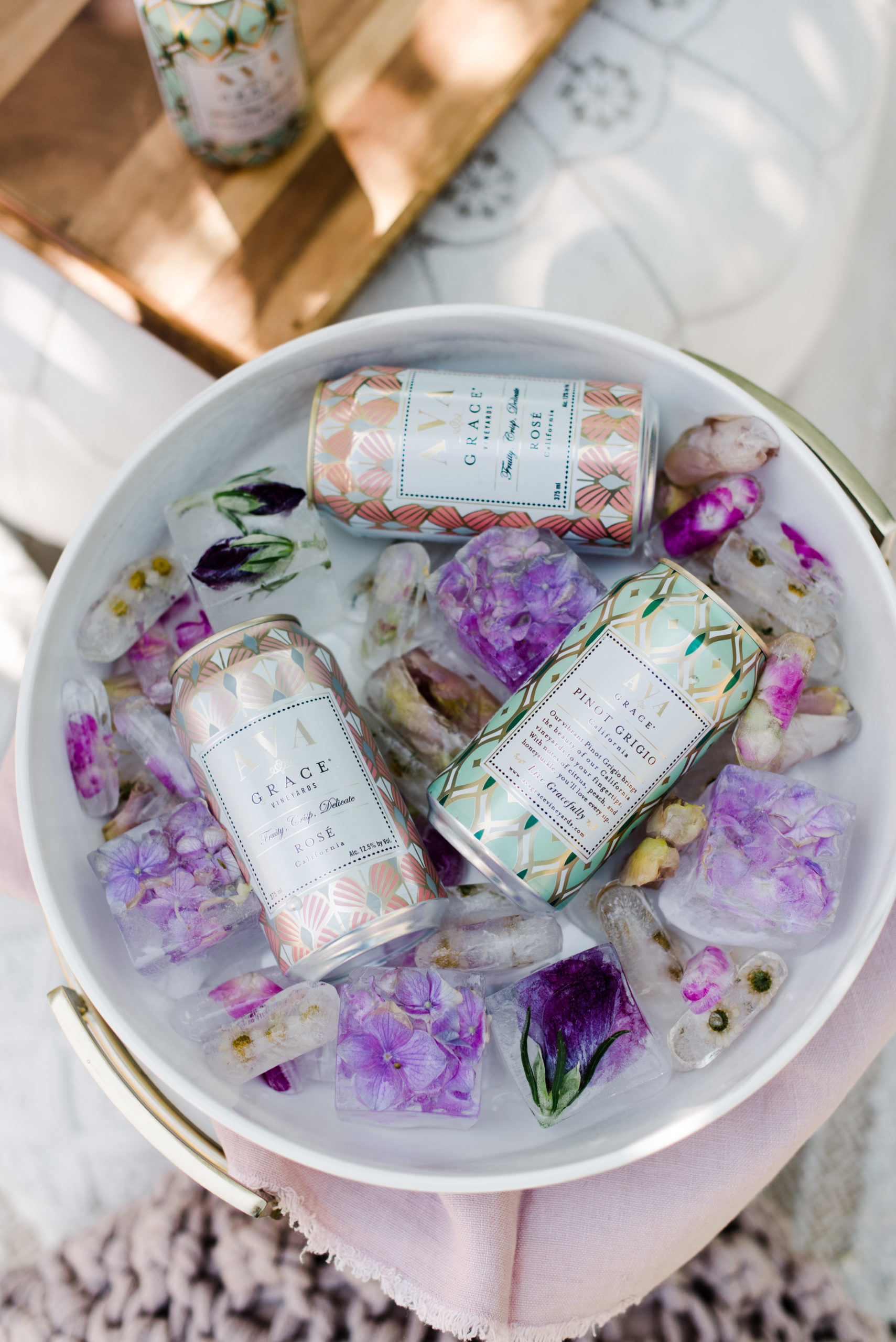 Can of AVA Grace wines in an ice bucket with beautiful floral ice cubes.