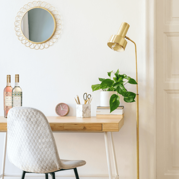 Beautiful desk space to WFH, with two bottles of AVA Grace and a plant on the desk.