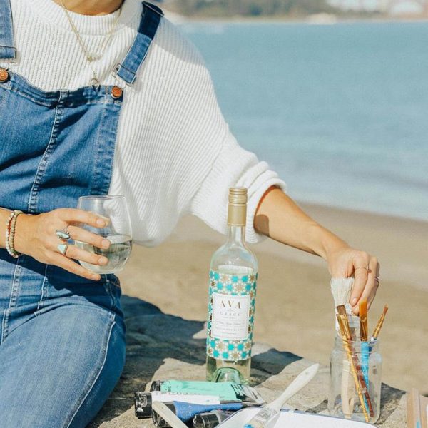 Women enjoying a glass of AVA Grace Pinot Grigio while painting by the bay.