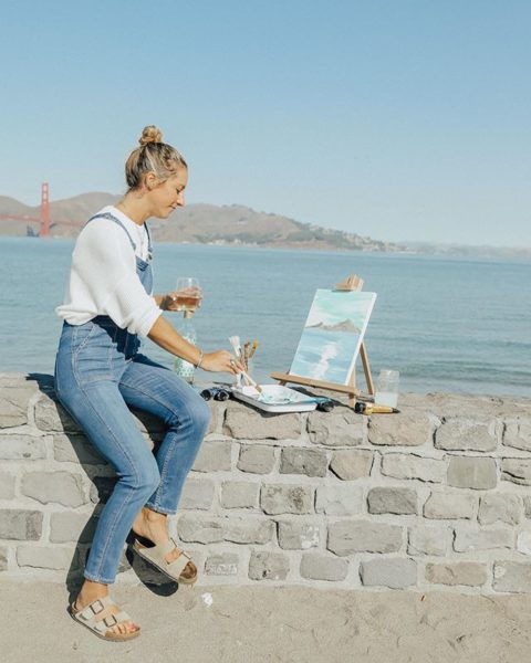 Women enjoying a glass of AVA Grace Pinot Grigio while painting by the bay.